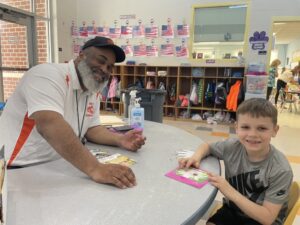 Middle Township School District bus driver sitting with an Elementary #1 student reading
