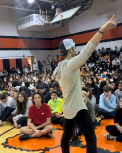 Jordan Toma stands in Middle Twp School District Gym presenting to young students