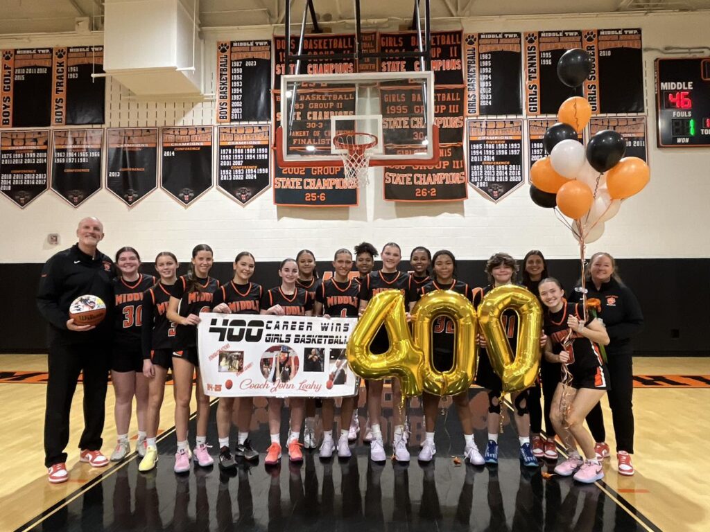 Leahy stands with the MTHS girls basketball team in the MTHS gym just after recording his 400th career win in a game against Absegami High School 