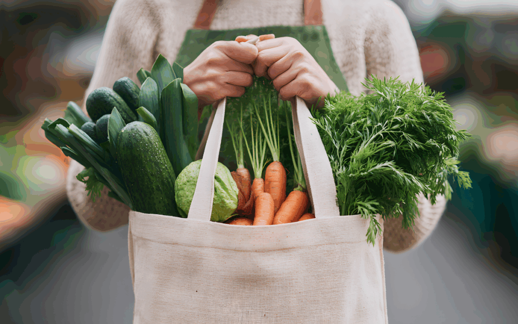 Person holding grocery bag with vegetables