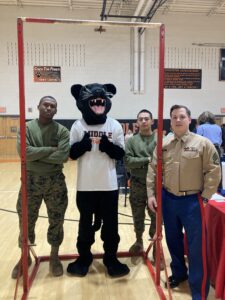MTSD's Panther posing with United States Marine Corps representatives after a friendly pull-up competition 