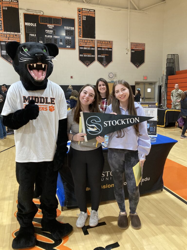 The Middle Township High School Panther posing for a photo with students interested gaining more information on Stockton University, an already partner of the district.  