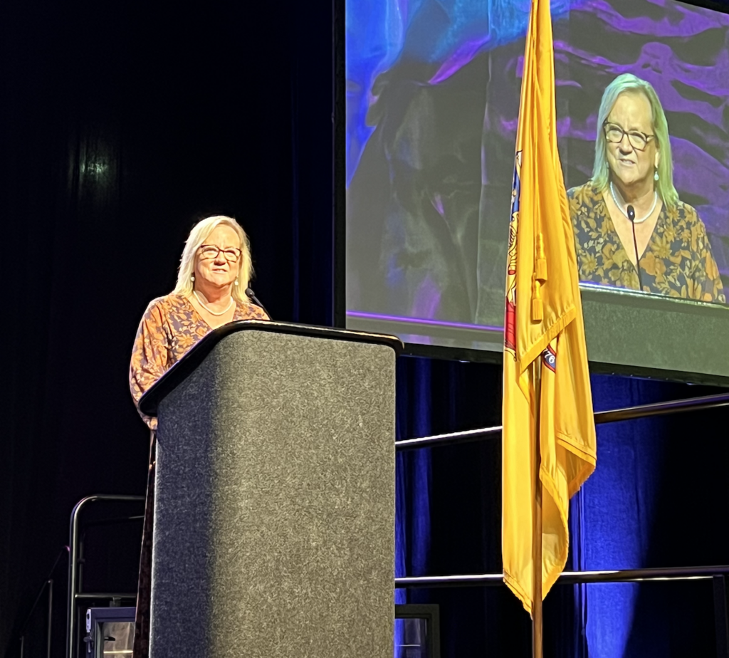 Dr. Diane Fox standing at a podium delivering a speech