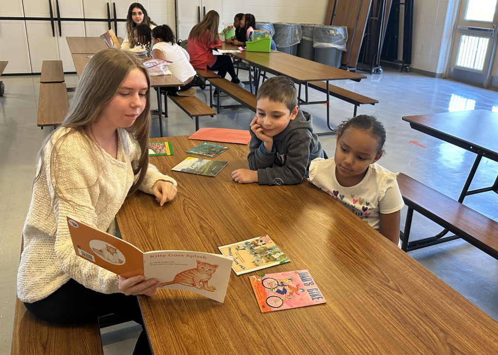 MTHS junior Sophia Hess reading to second graders Kingston Davido and Jaela Jones. 