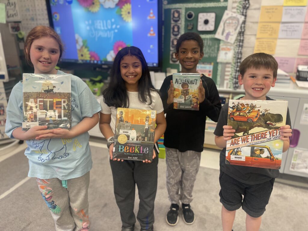 Third graders holding books written and illustrated by Dan Santat. 