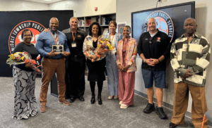 Middle Township Elementary #1 teacher Andrea Davis (daughter), Middle Township Middle School Assistant Principal Andre Hodges, Superintendent Dr. David Salvo, Middle Township Middle School teacher Christal Homes (daughter), Middle Township High School Principal Dr. Sharon Rementer, Board of Education President Stephanie Thomas, former BOE member Dennis Roberts, and BOE member Burgess "Butch" Hamer pose with a dedication plaque on behalf of Gloria Hodges.