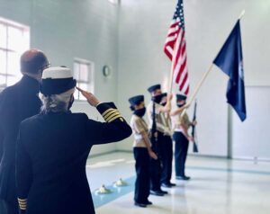 Captain Maureen Harden-Lozier, U.S. Navy (retired) saluting the American Flag