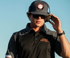 Football coach communicating through headset during football game